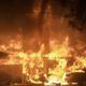 A fire tornado appears above a burning house.